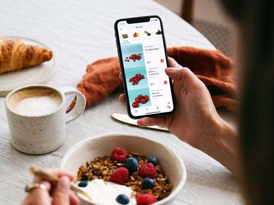 Woman looking at phone during breakfast